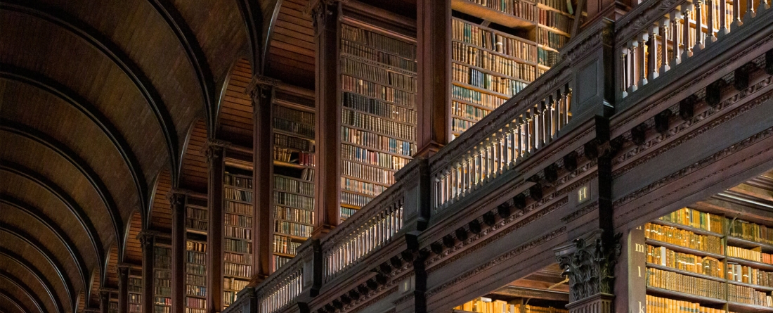 Old library with wood arches and shelving holding old books