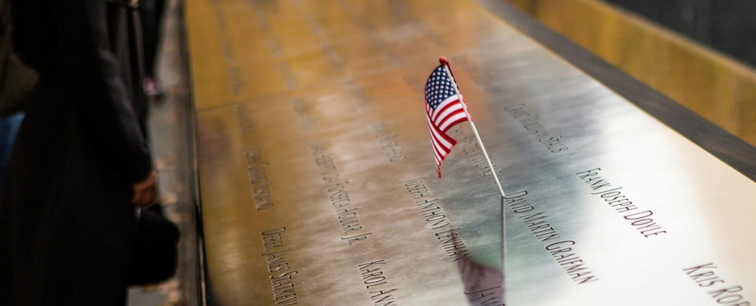 people standing at 9/11 memorial in NYC